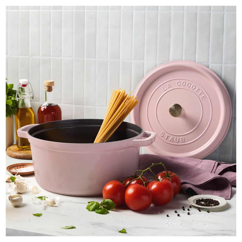 Staub | Round Dutch Oven, Pink Peony, 7 QT, filled with upright spaghetti, surrounded by tomatoes, basil, garlic, and spices, creating a vibrant pasta prep scene.