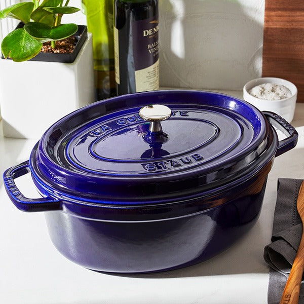 Staub | Coq au Vin Dutch Oven, Dark Blue, 5.75 QT., elegantly sits on a kitchen counter with kitchen essentials, embodying Athens Cooks' curated cookware selection.
