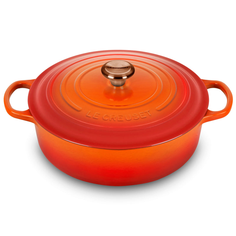 Le Creuset Signature Round Wide Oven in Flame, a 6.75-quart enameled cast-iron Dutch oven with side handles and a tight-fitting lid, ideal for versatile cooking.