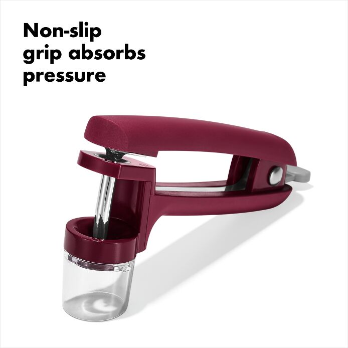 OXO Good Grips Cherry & Olive Pitter in Beet showing non-slip grip and splatter shield for easy and clean pitting of cherries and olives.