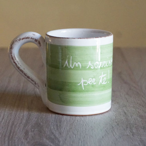 La Gabbianella | Magia, Mug, Green Tree: White ceramic mug with Un sorriso per te! in green, hand-brushed band, handmade in Italy, on a wooden surface.
