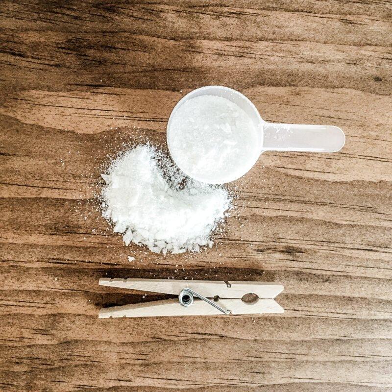 Humble Suds | Laundry Soap in a measuring cup, shown on a wooden surface, highlights its powder form ideal for effective, natural cleaning.