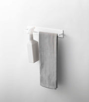 Yamazaki Home | Magnetic Kitchen Towel Hanger, Steel, White, with a spray bottle and grey kitchen towel displayed, showcasing its functional design for organized kitchen storage.
