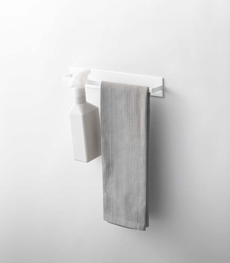 Yamazaki Home | Magnetic Kitchen Towel Hanger, Steel, White, with a spray bottle and grey kitchen towel displayed, showcasing its functional design for organized kitchen storage.