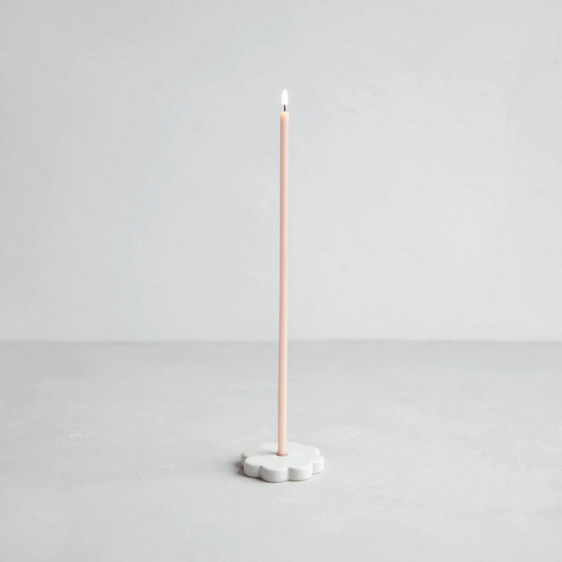 The Floral Society | Long Stem Beeswax Candle in pale pink, elegantly set in a white flower-shaped holder, offering a warm, minimalist glow for intimate settings.