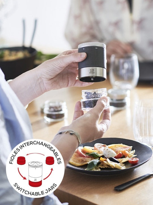 Peugeot Maestro Pepper Bar with switchable jars in use, alongside fresh pasta, showcasing its precision engineering and versatility for culinary exploration.