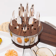 Christofle | MOOD Party 24 Pieces set with white ceramic dishes and a wooden-and-stainless-steel caddy, featuring polished metal utensils for elegant entertaining.