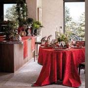 Le Jacquard Francais | Féerie Tablecloth, Red, 69 x 98 adorns a festive dining table, featuring a rich damask pattern, enhancing holiday gatherings with elegance and warmth.