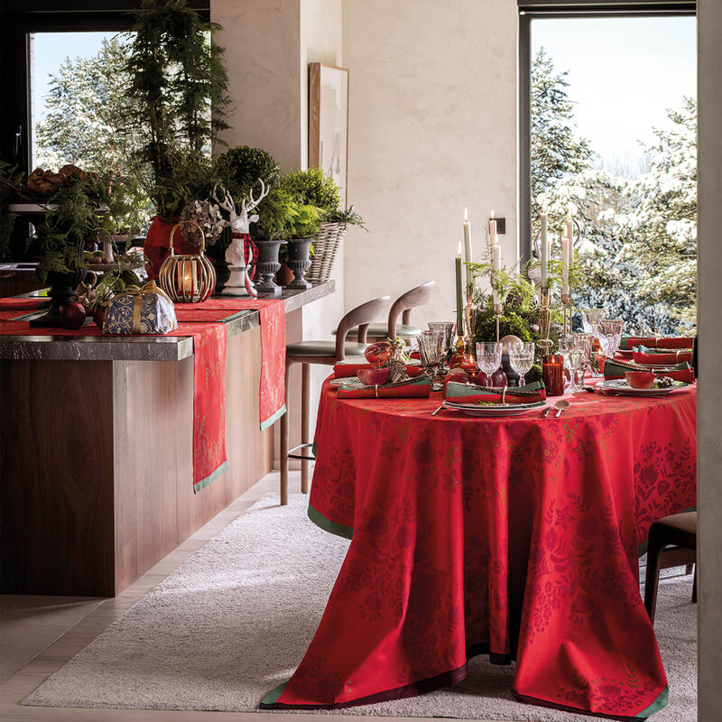 Le Jacquard Francais | Féerie Tablecloth, Red, 69 x 98 adorns a festive dining table, featuring a rich damask pattern, enhancing holiday gatherings with elegance and warmth.