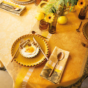 Le Jacquard Francais | Gipsy Tablecloth in yellow supports a brunch setting with floral motifs, copper flatware, amber glasses, and lemons, evoking a bohemian, global ambiance.