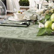 Le Jacquard Francais Tivoli Tablecloth in green elegantly adorns a formal table setting with china, cutlery, and decorative elements, showcasing its timeless elegance.