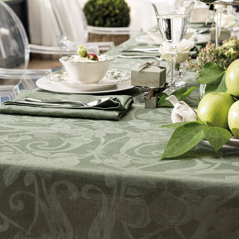 Le Jacquard Francais Tivoli Tablecloth in green elegantly adorns a formal table setting with china, cutlery, and decorative elements, showcasing its timeless elegance.