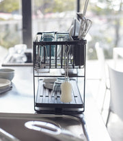 Yamazaki Home | Two-Tier Dish Rack, White: Efficiently air-dry dishes with this steel rack featuring customizable tiers, utensil holder, and 360-degree draining spout for clutter-free countertops.