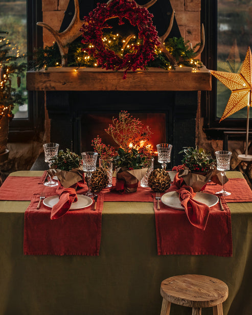 MagicLinen's 59 x 98-inch olive green linen tablecloth, featuring a simple seam finish, ideal for elevating both casual and formal dining settings.