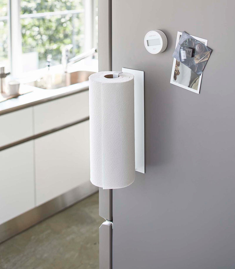 Yamazaki Home Magnetic Steel Paper Towel Holder on fridge door, with kitchen timer and photo magnets, in a modern kitchen.