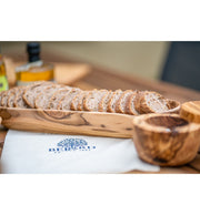 Sliced bread in a BERARD Olivewood Bread Basket, 13.75/35cm, showcasing the elegant craftsmanship available at Athens Cooks kitchen store.