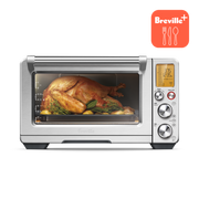 Breville | Smart Oven Air Fryer Pro displaying a roast chicken with herbs and potatoes, featuring a digital display and control dials. Ideal for versatile countertop cooking.