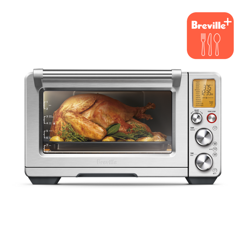 Breville | Smart Oven Air Fryer Pro displaying a roast chicken with herbs and potatoes, featuring a digital display and control dials. Ideal for versatile countertop cooking.