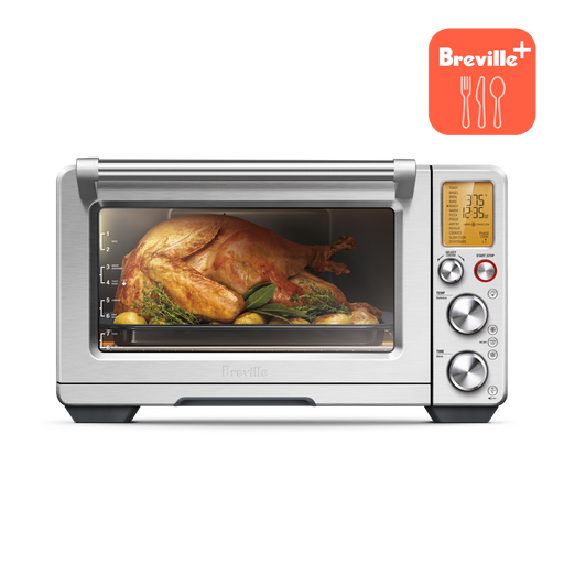 Breville | Smart Oven Air Fryer Pro displaying a roast chicken with herbs and potatoes, featuring a digital display and control dials. Ideal for versatile countertop cooking.