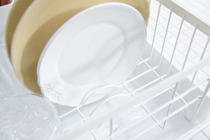 Yamazaki Home | Steel + Wood Dish Rack with Drainer Spout, showcasing clean plates and a tumbler, elegantly combines style with function for a refined kitchen experience.