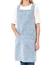 MagicLinen Pinafore Cross-Back Linen Apron in Dusty Blue, featuring criss-cross straps and side pockets, ideal for cooking or gardening.