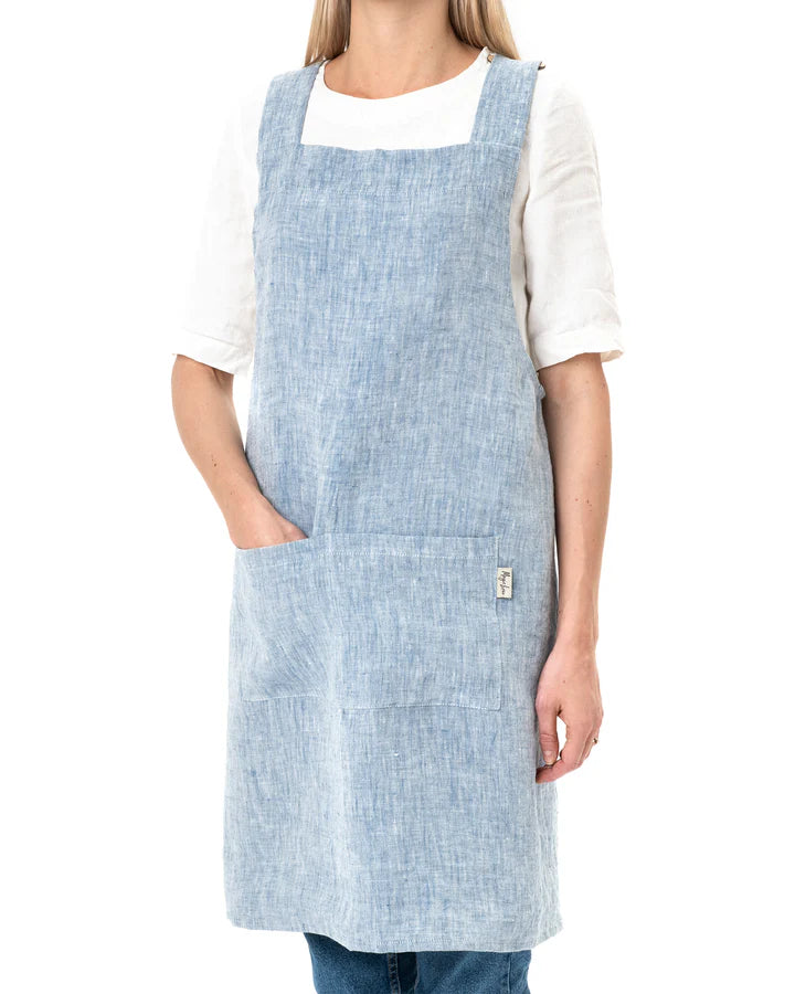 MagicLinen Pinafore Cross-Back Linen Apron in Dusty Blue, featuring criss-cross straps and side pockets, ideal for cooking or gardening.