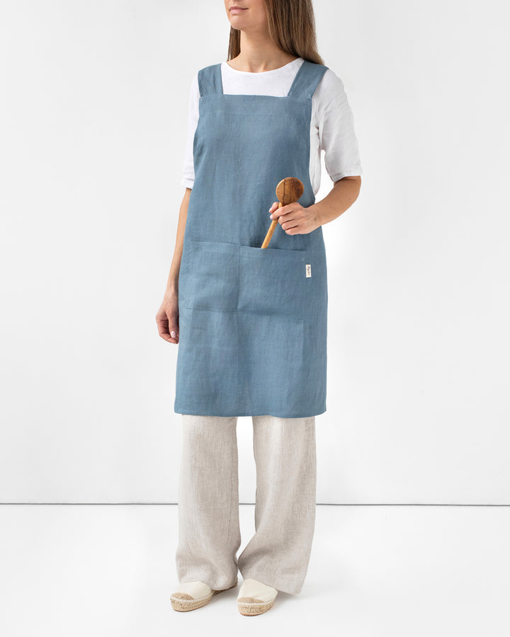 MagicLinen Pinafore Cross-Back Linen Apron in Gray Blue with criss-cross straps and side pockets, ideal for cooking or gardening.