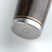 Shun | Premier Serrated Utility Walnut, 6.5 knife's pommel features dark wood handle, brass spacer, black liner, and stainless steel end-cap with logo.