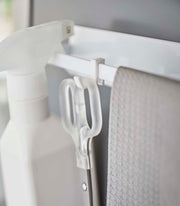 Yamazaki Home | Magnetic Kitchen Towel Hanger, Steel, White, holding a spray bottle, scissors, and cloth on a white rail, showcasing versatile kitchen organization.