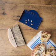 Andrée Jardin | Clynk Natural Crumb Tray Set featuring a beechwood brush and metal pan, displayed alongside pastries, highlighting its practicality for kitchen tidiness.