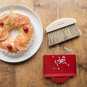 Andrée Jardin | Clynk Natural Crumb Tray Set with a beechwood brush and metal pan, elegantly displayed with a bagel and fruit on a plate.