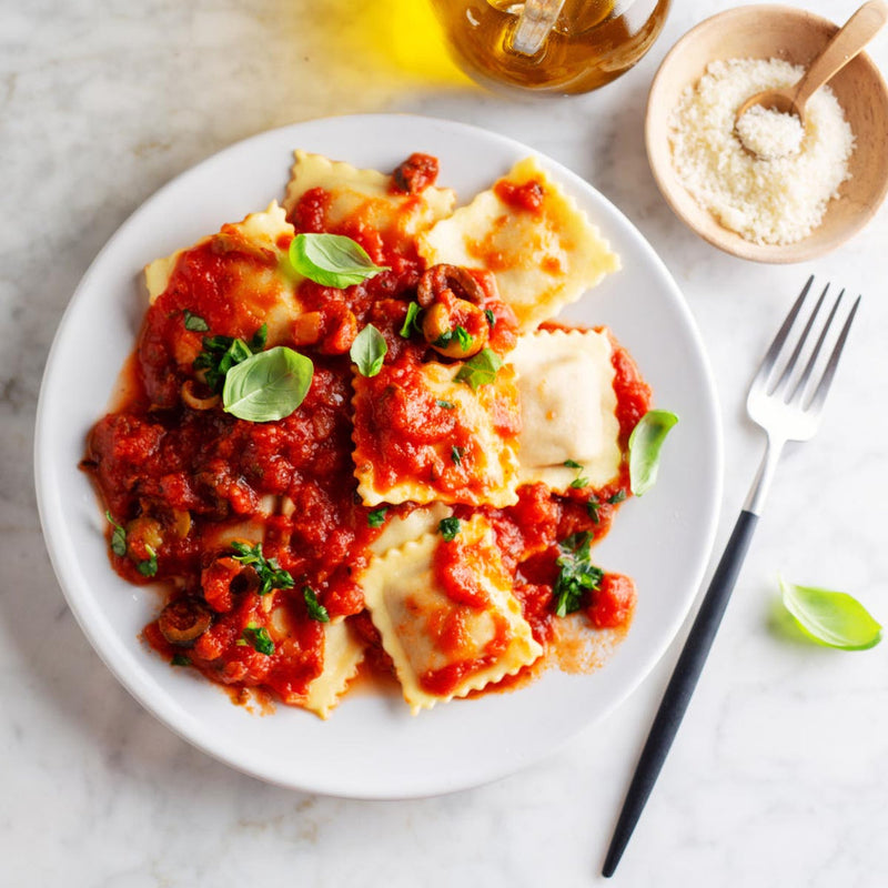 Marcato Ravioli Tablet Pasta Makers (Black) with ravioli on plate, showcasing ease of use for crafting perfect homemade ravioli.