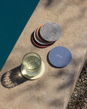 Graf Lantz | Bierfilzl Merino Wool Round Coaster Multi 6 Pack in Santa Fe displayed by a pool, emphasizing elegant and durable surface protection.