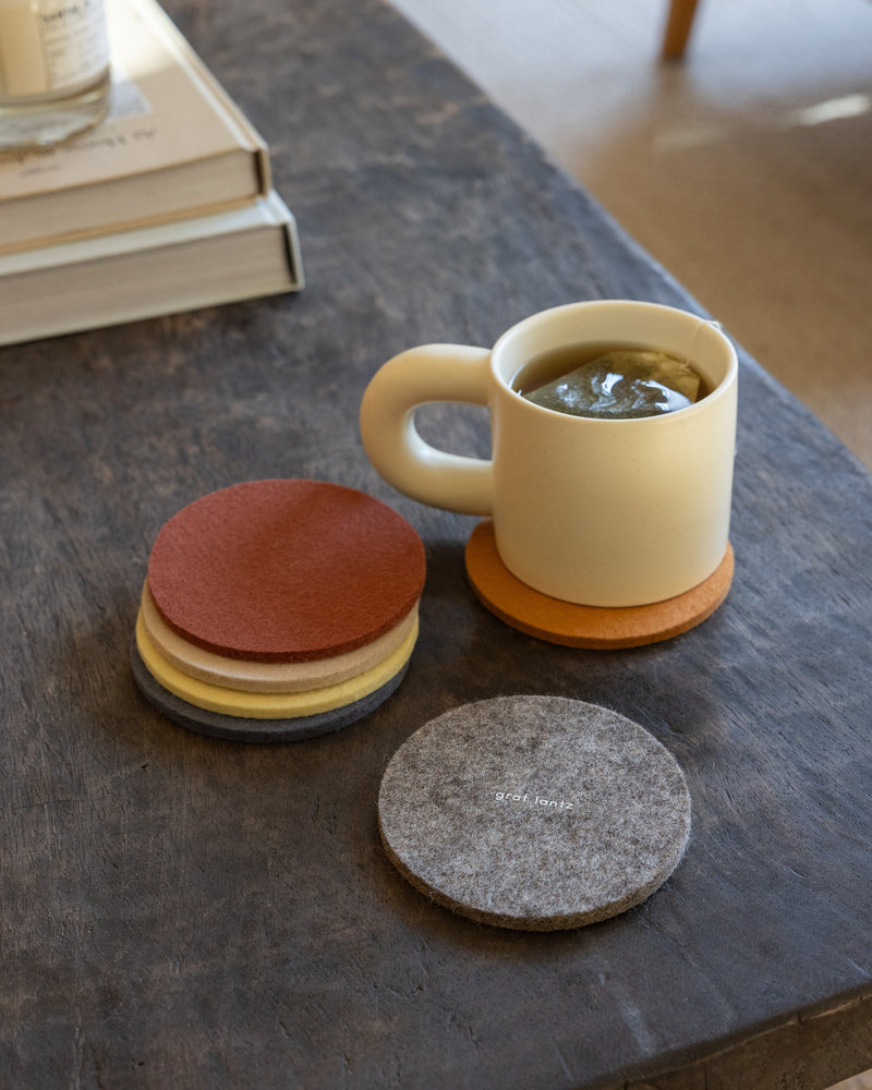 Graf Lantz | Bierfilzl Merino Wool Round Coaster Multi 6 Pack in Santa Fe, featuring stacked coasters beside a teacup, highlighting durable, elegant design for surface protection.