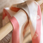 Le Jacquard Francais | Bal Des Papillons Napkin, Pink, elegantly draped, showcasing butterfly-like motifs and polychrome stripes on silky fabric. Perfect for adding a whimsical touch to dining.