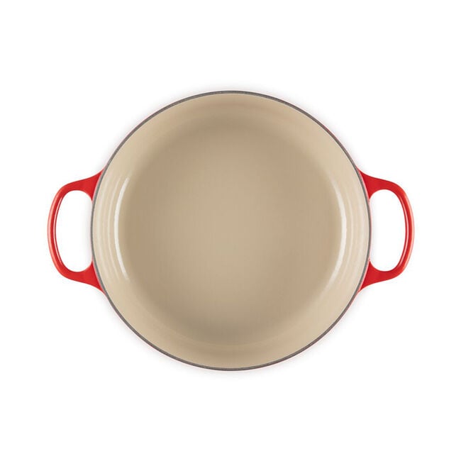 Le Creuset | Signature Round Wide Oven, Cerise, empty with a cream-colored interior, ideal for versatile cooking. Red enameled exterior with handles enhances kitchen elegance.