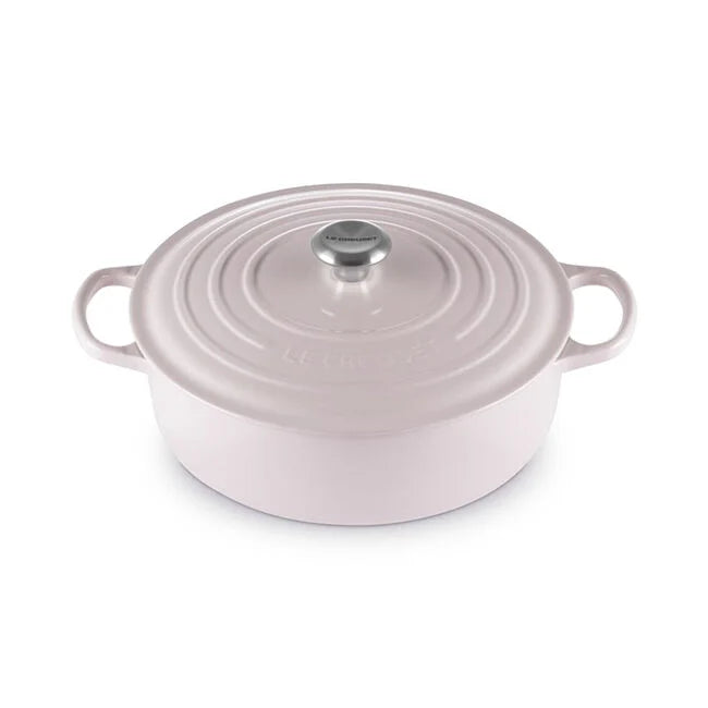 Le Creuset | Signature Round Wide Oven - Shallot, a pastel pink enameled cast-iron Dutch oven with side handles and a fitted lid, ideal for versatile cooking.