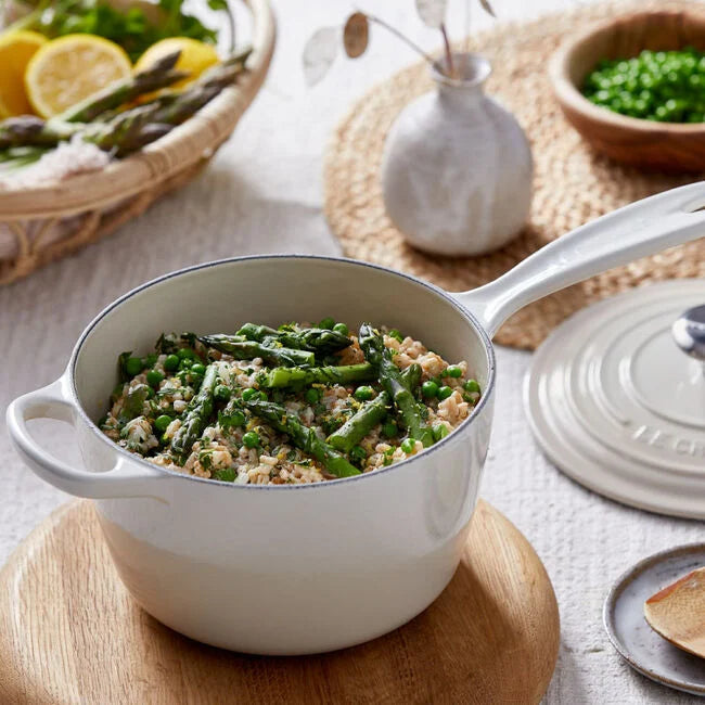 Le Creuset | Signature Saucepan on a wooden board, showcasing its smooth curved interior and handles, ideal for sauces and grains.