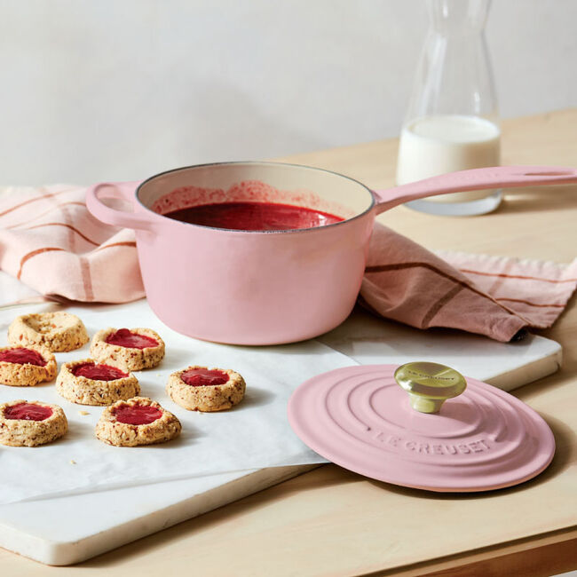 Le Creuset | Signature Saucepan shown with pink lid, perfect for sauces and reheating, accompanied by cookies and a glass bottle of milk.