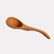 Jonathan's Cherry Wood Ladle from the Lazy Spoon® + Ladle Collection, designed for mess-free serving, elegantly rests on pots, enhancing any culinary setting.