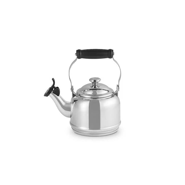 Le Creuset stainless-steel stovetop whistling tea kettle with domed lid, curved spout, flip-up whistle cap, and black heat-resistant handle, ideal for Athens Cooks' curated kitchenware.