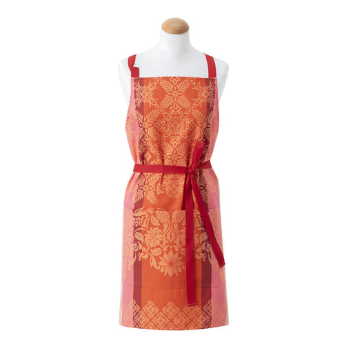 Le Jacquard Français | Mumbai Apron, Orange: A vibrant red and orange apron with floral damask patterns, featuring a neck strap, front pocket, and bow-tied waist strap.