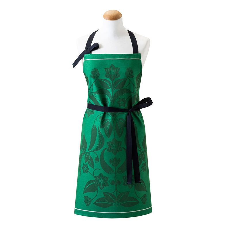Le Jacquard Francais PIMENTS APRON features a stylish green design with black straps, ideal for kitchen enthusiasts seeking functional and elegant cooking attire.