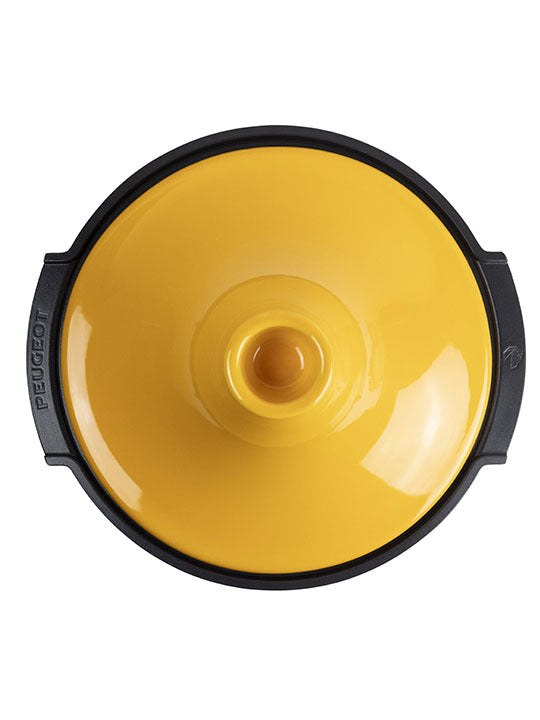 Peugeot | Appolia Atlas Tagine, Saffron Yellow: Top-down view of a round, enameled cast-iron lid with black handles, perfect for even heat distribution and versatile cooking.