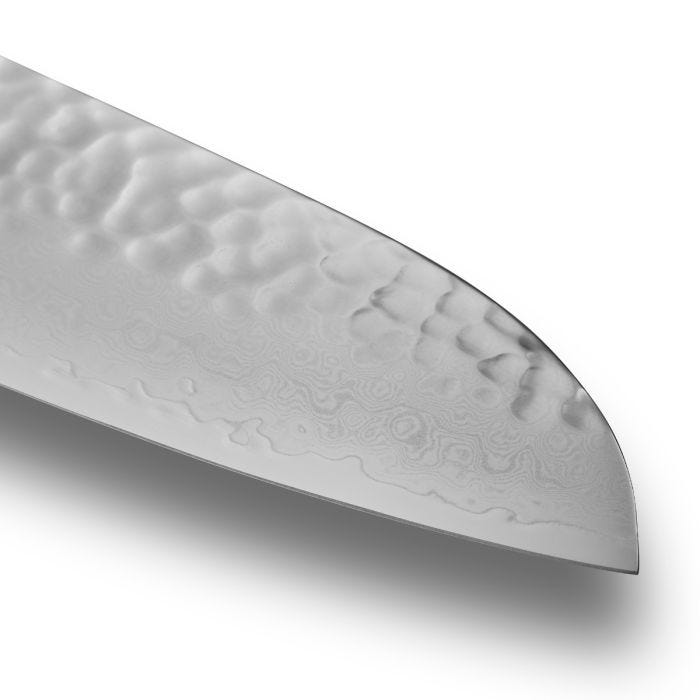 Close-up of Shun Premier Santoku Walnut, 7 knife tip showing hammered tsuchime finish and Damascus pattern, highlighting its craftsmanship and functionality for versatile kitchen use.