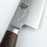 Shun Premier Chef's Knife, 6 inches, with a hammered Damascus blade and stamped kanji, featuring a wooden handle and metal bolster, ideal for nimble culinary tasks.