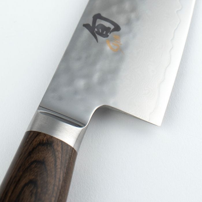 Shun Premier Chef's Knife, 6 inches, with a hammered Damascus blade and stamped kanji, featuring a wooden handle and metal bolster, ideal for nimble culinary tasks.