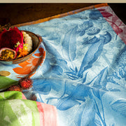 Le Jacquard Français | Équateur Tea Towel, Blue, showcasing vibrant tropical fruits and blossoms on a floral-patterned cloth, highlighting exotic kitchen elegance from Athens Cooks.