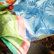 Le Jacquard Français | Équateur Tea Towel, Green, draped on rustic wood, showcases exotic botanical motifs, enhancing kitchen decor with vibrant, woven elegance.