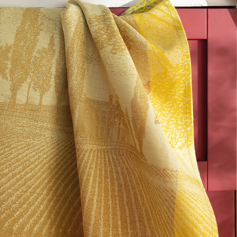 Le Jacquard Français | Vignoble Tea Towel, Yellow, jacquard-woven with a pastoral scene, draped over a red wooden frame, showcasing Burgundy's vineyard-inspired design.